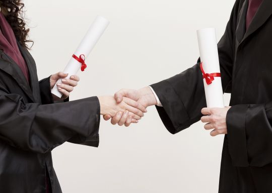 students shaking hands with the obtained diploma